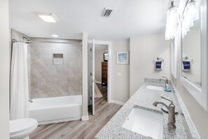 Une salle de bain moderne équipée d’une douche, d’une baignoire et de deux lavabos.