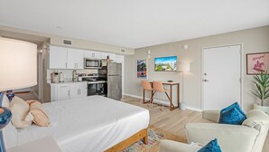 Une chambre d’hôtel moderne équipée d’un lit, d’un canapé, d’un coin repas et d’une kitchenette.