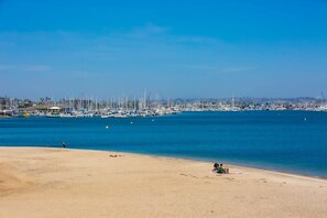 A beach with a marina in the background.