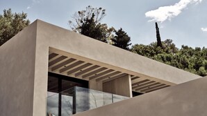 Un edificio moderno con techo plano, amplios ventanales de vidrio y diseño minimalista.