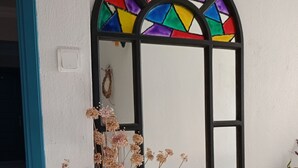 A room with a large mirror, a vase with dried flowers, and a small table with a potted plant. - Ayvalık Leya Pansiyon (Ayvalik)