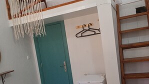 A room with a bunk bed, a teal door, a white radiator, and a patterned rug. - Ayvalık Leya Pansiyon (Ayvalik)