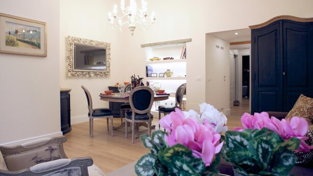 A dining area with a chandelier, a dining table with chairs, a mirror, and a bookshelf. - Santa Reparata in Firenze (Florence)