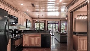 A spacious kitchen with wooden cabinets, a black refrigerator, and a central island.
