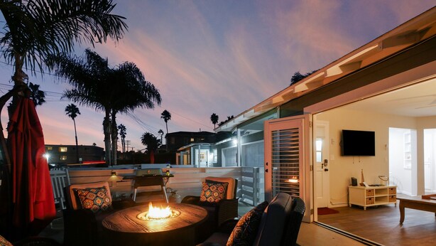 An outdoor seating area with a fire pit, comfortable chairs, and a view of the property. - "SHORE BREAK" HOUSE... Where Turf Meets Surf! (Oceanside)