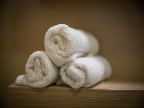 A stack of white towels on a wooden surface. - City Holiday Apartment (Dubrovnik)
