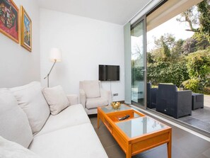 A modern living room with a sofa, armchairs, a coffee table, and a TV. - City Holiday Apartment (Dubrovnik)