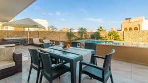 A rooftop patio with a pool, outdoor furniture, and a view of the cityscape. - Wellness Hygge Modern Gozitan Apartment (Xaghra)