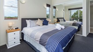 A modern hotel room with a large bed, a bedside table with a lamp, a mirror, and a view of the outdoors. - Awesome, modern, open-plan 3rd floor (with lift) unit with stunning water views. (Bongaree)