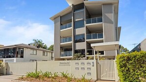 A multi-story residential building with balconies, a gated entrance, and a clear sky. - Awesome, modern, open-plan 3rd floor (with lift) unit with stunning water views. (Bongaree)