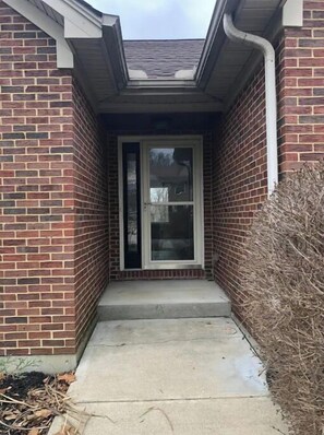 Step up to a welcoming entrance with a glass door and skylight above.
