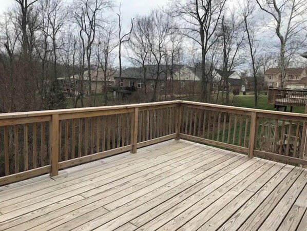 Enjoy an outdoor space with a deck offering views of the surrounding neighborhood and trees.