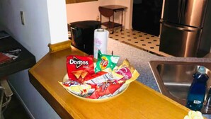 A kitchen with a wooden countertop, a bowl of chips, a refrigerator, and a sink. - Location!! Close to Everything! Spacious and Fun! (Lexington)