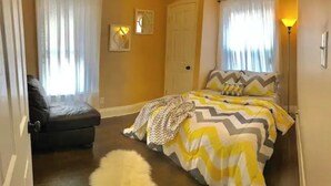 A bedroom with a bed, a chair, and a lamp. - UK/Rupp/Downtown-3 Bedroom-3 Bath!! (Lexington)