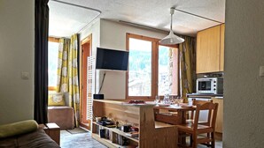 A compact living space with a kitchenette, a dining area, and a sofa. - La Clairière 1 - Nice divisible studio with a mountain view (LES AVANCHERS VALMOREL)