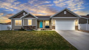 A two-story house with a front entrance, a garage, and a well-maintained lawn.
