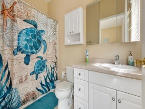 Un baño con un mural de mapa, un inodoro blanco, un lavabo y un armario.