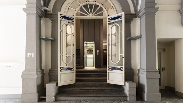 A grand entrance with a staircase leading to a door with glass panels. - Matteotti Apartment in Firenze (Florence)