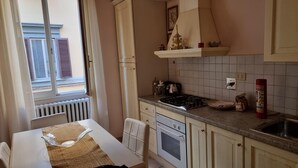 Une cuisine avec une fenêtre, une cuisinière, un four et un évier.