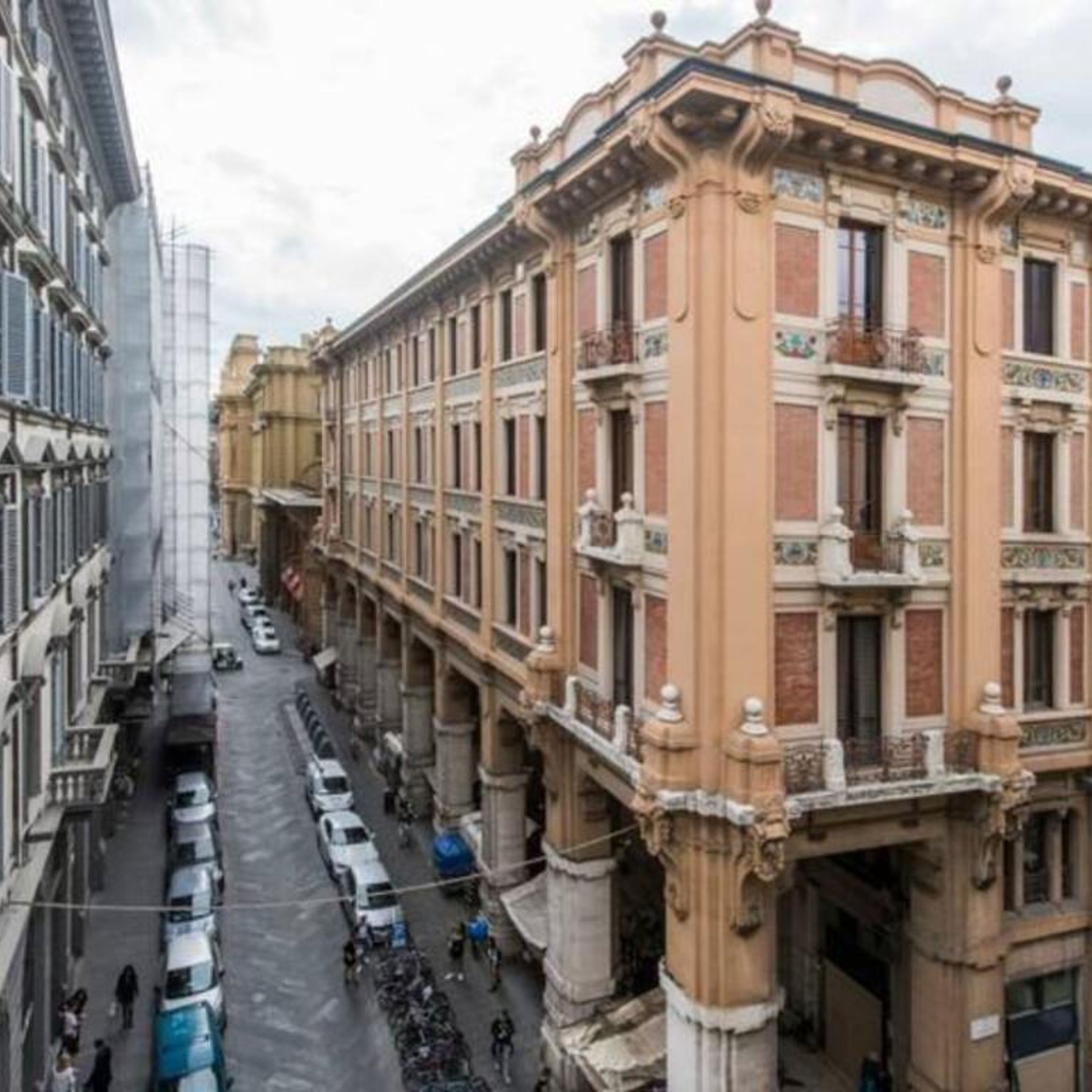 A street view of a building with a classic architectural style, featuring ornate facades and multiple balconies.