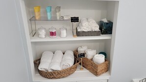 Ein Regal mit Pflegeprodukten, Badetüchern und Handtüchern.