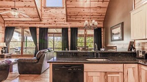 A wooden interior with a kitchen island, dining area, and a sofa. - Cozy Retreat N Smoky, Sleeps 6・Hot Tub・Pool Table (Pigeon Forge)