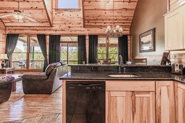 Un interior de madera con una isla de cocina, comedor y un sofá.
