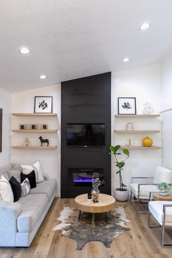 Smart TV, chimenea, libros, biblioteca de música
