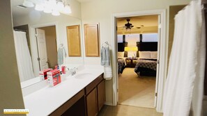 Een bad/douchecombinatie, een haardroger, handdoeken, zeep