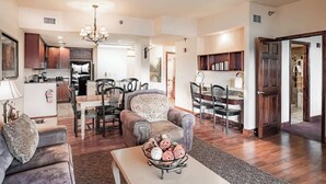 A spacious living area with a dining table, chairs, a sofa, and a coffee table with decorative items. - Cozy Suite, Sleeps 6・Jacuzzi, View + Resort Perks (Pigeon Forge)
