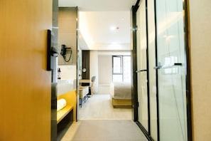 A modern hotel room with a bed, a desk, a chair, and a glass shower enclosure. - Shankee Tea Style Hotel (Kunming South High-Speed Railway Station Chunrong Street Subway Station) (Kunming)