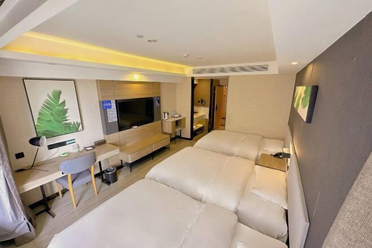 Une chambre d’hôtel moderne équipée d’un grand lit, d’un bureau, d’une télévision et d’une salle de bain.