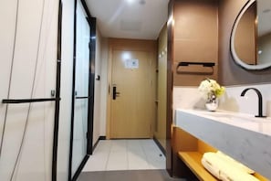 A modern bathroom with a glass door, a wooden vanity, a sink, and a mirror. - Shankee Tea Style Hotel (Kunming South High-Speed Railway Station Chunrong Street Subway Station) (Kunming)