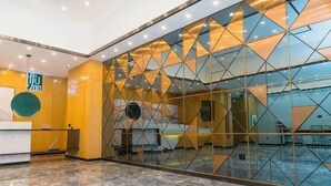 A hotel lobby with a reception desk, a glass partition with geometric patterns, and a marble floor. - Shankee Tea Style Hotel (Kunming South High-Speed Railway Station Chunrong Street Subway Station) (Kunming)