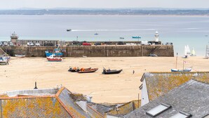 A coastal town with a sandy beach, boats, a lighthouse, and a pier. - Secret Cottage, St Ives – Sleeps 6 – Sea Views – Garden (St Ives)