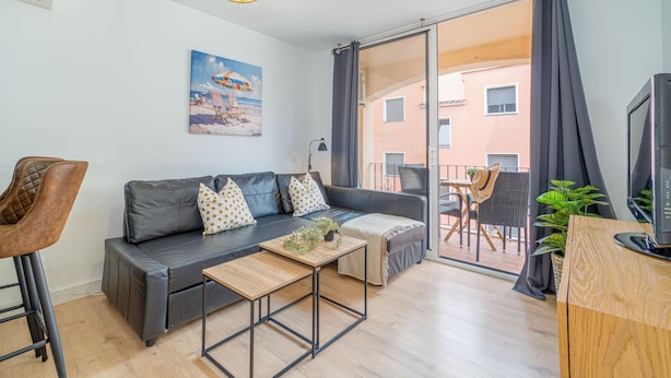 A modern living room with a sofa, coffee table, and a TV. - Apartment in the center completely renovated (Empuriabrava)