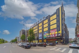 Un hotel de varios pisos con grandes ventanales y un letrero llamativo en la fachada.