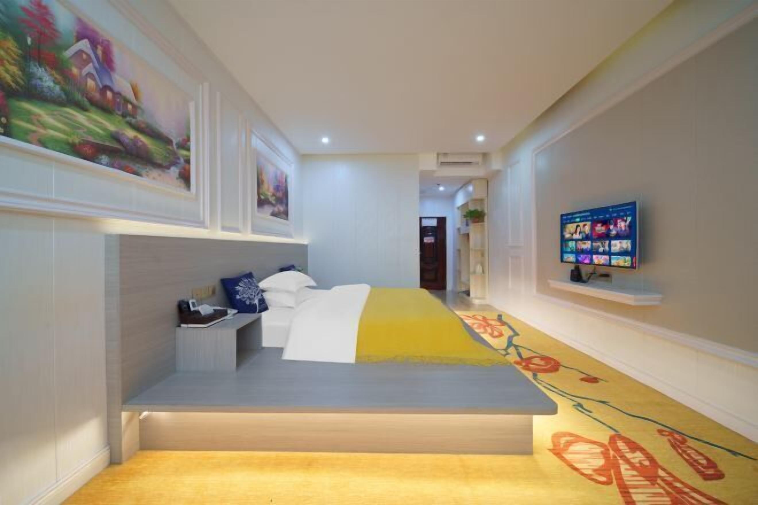 Una habitación de hotel con una cama, un televisor y un cuadro en la pared.