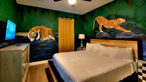 A bedroom with a bed, a ceiling fan, a TV, and a mural of a tiger. - Bowling, Safari-themed, Private Pool, 1GB WiFi, video wall TV, sleeps 40 (Kissimmee)