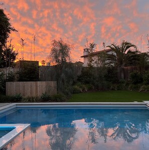 Una piscina con vistas despejadas al jardín circundante y una valla de madera.
