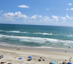 A beach with clear skies and calm waves. - Spacious, kid-friendly 3BR beachfront condo, close to Orlando theme parks (Daytona Beach)