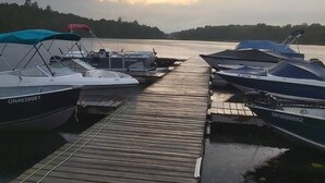 A wooden dock with several boats moored on either side. - Ahmic Lake Resort's 2-Bedroom Cottage with Hot Tub (Gray Wolf Cottage) (Magnetawan)