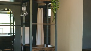A modern room with a dark wooden desk, a metal shelving unit, and a potted plant. - Sol del Valle (Valle de Guadalupe)