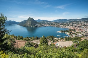 Un pueblo costero con una montaña destacada, un puerto deportivo y edificios residenciales.