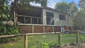 A single-story RV with a large window and a covered porch area.