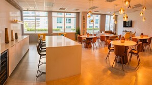 A modern hotel lobby with a central island, multiple seating areas, and large windows offering views of the outside. - Lovely Brickell Oceanview Studio (Miami)