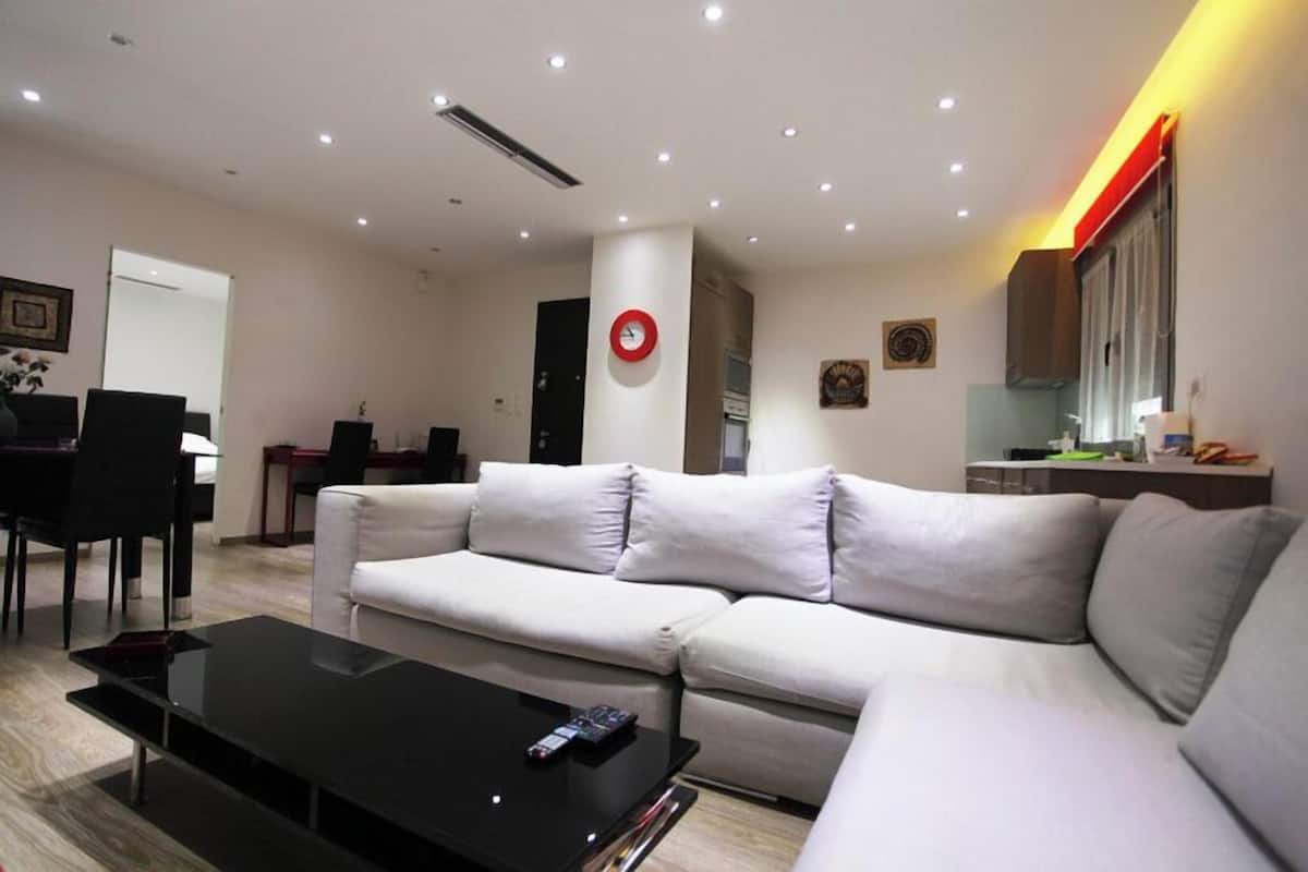 Una sala de estar moderna con un sofá, una mesa de centro y un comedor con sillas.