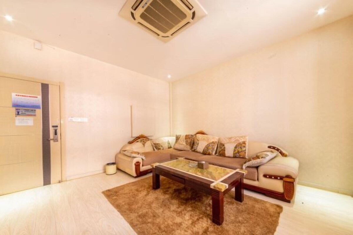 Una sala de estar con un conjunto de sofás, una mesa de centro y una puerta con un letrero.