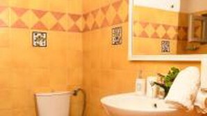 A bathroom with a toilet, sink, and mirror. - Impeccable Double Bed Villa in Imerovigli Santorin (Santorini)