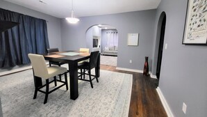 A dining area with a table and chairs, a rug, and a painting on the wall. - Bright & Cozy, near downtown & hiking trails (Birmingham)